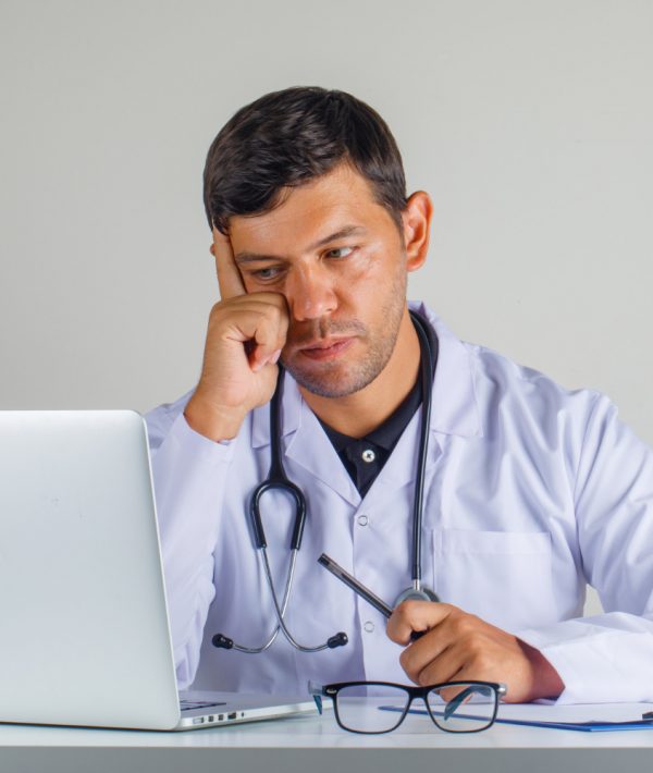 doctor-white-coat-stethoscope-sitting-looking-laptop-looking-careful doctor-white-coat-stethoscope-sitting-looking-laptop-looking-careful
