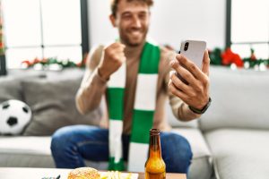 A man watching a football match on his phone