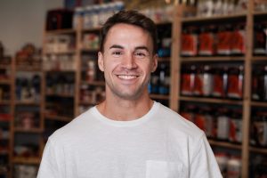 Man in from of his business smiling